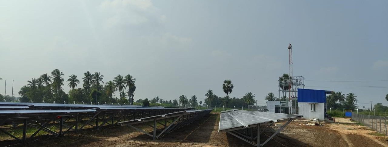 Rows of ground-mounted solar panels beside the control room and switch yard at the Tiruvannamalai site